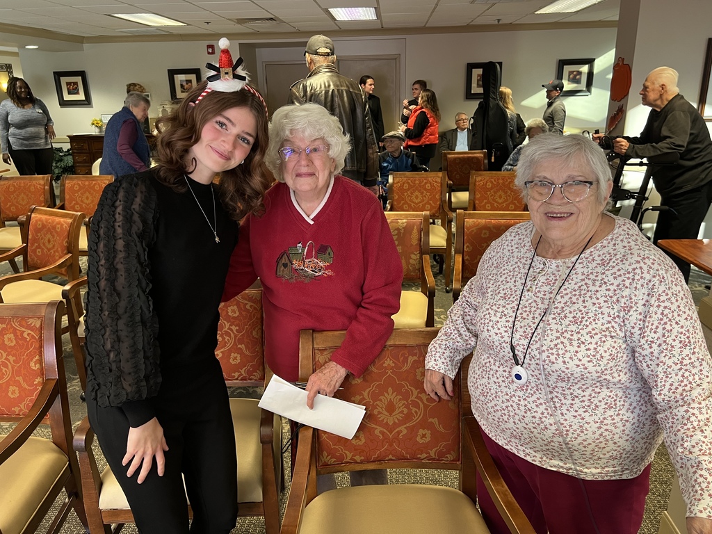 Student smiling with residents of a senior living community.