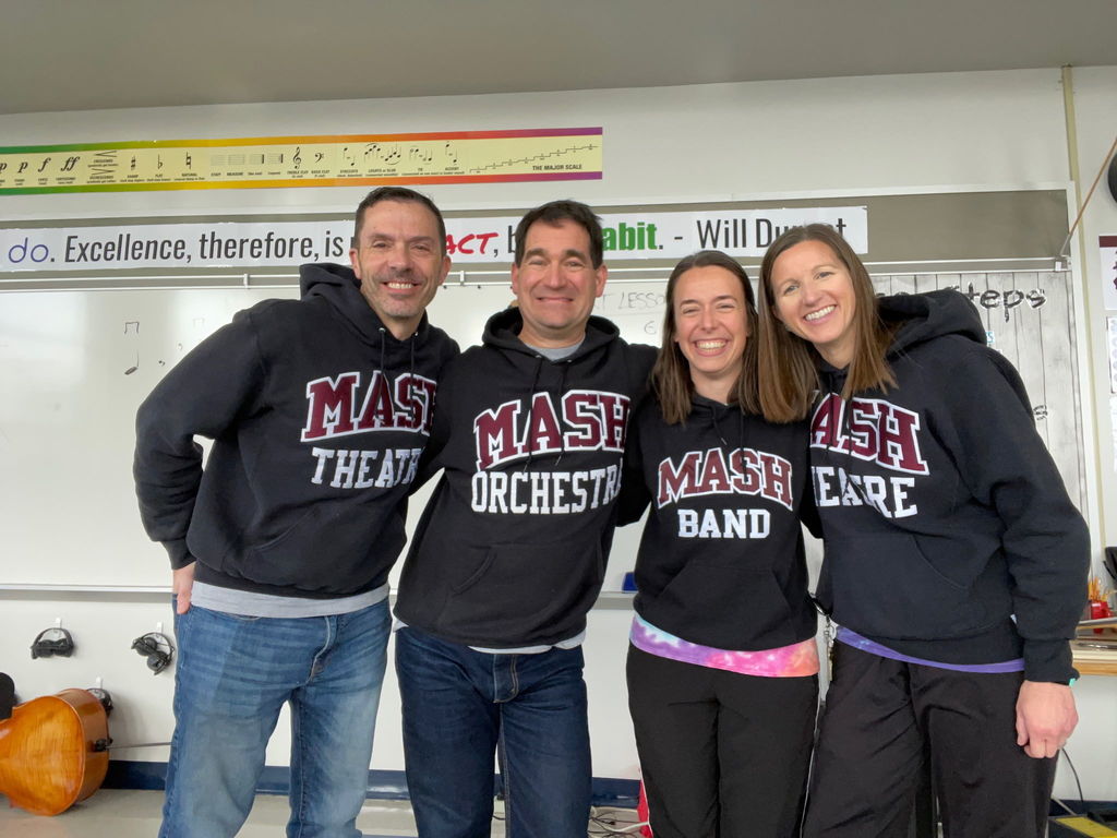 A group of staff wearing MASH music sweatshirts.