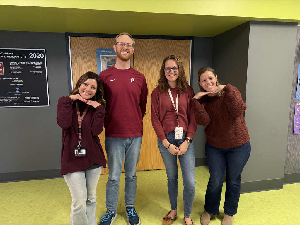 Teachers pretending to be taking a photo for a holiday card.
