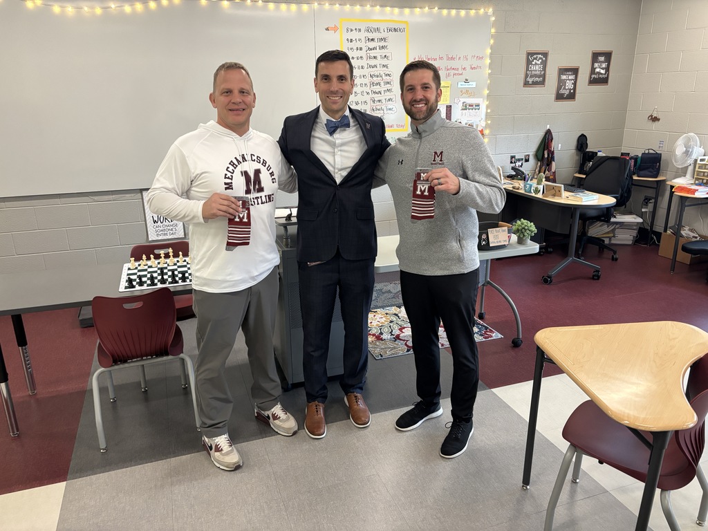 Two men showing the branded socks they earned from the superintendent.