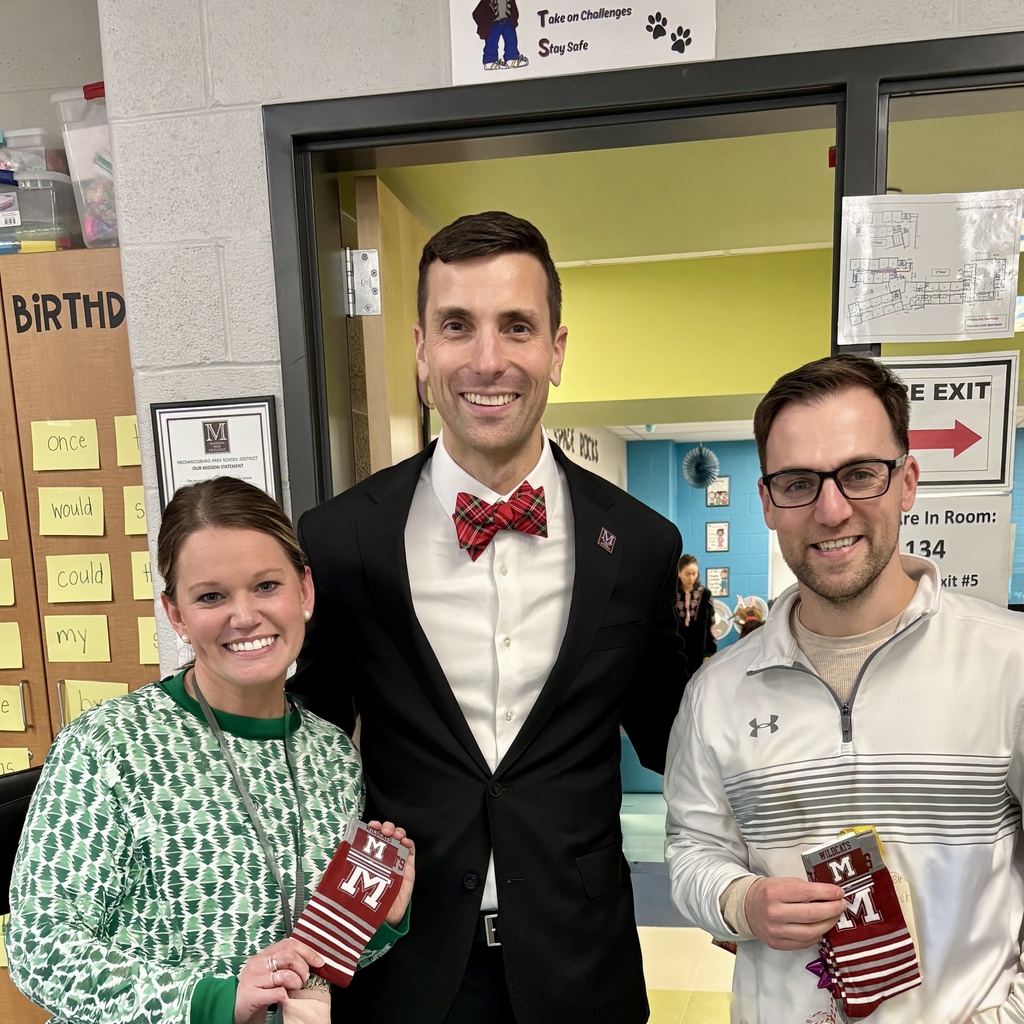 Two staff members holding branded socks as presented by the superintendent.