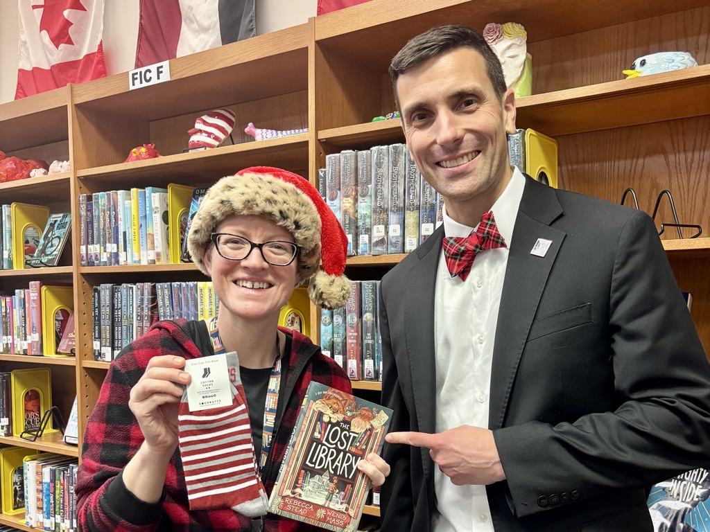 A school librarian poses with a pair of branded socks she received from the superintendent.