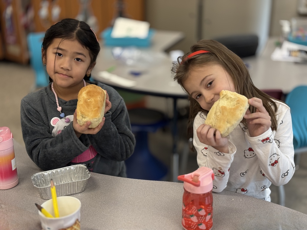 Two young students hold up their homemade bread.
