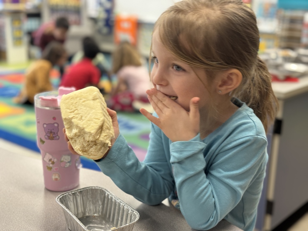 A young student enjoys a bite of homemade bread.