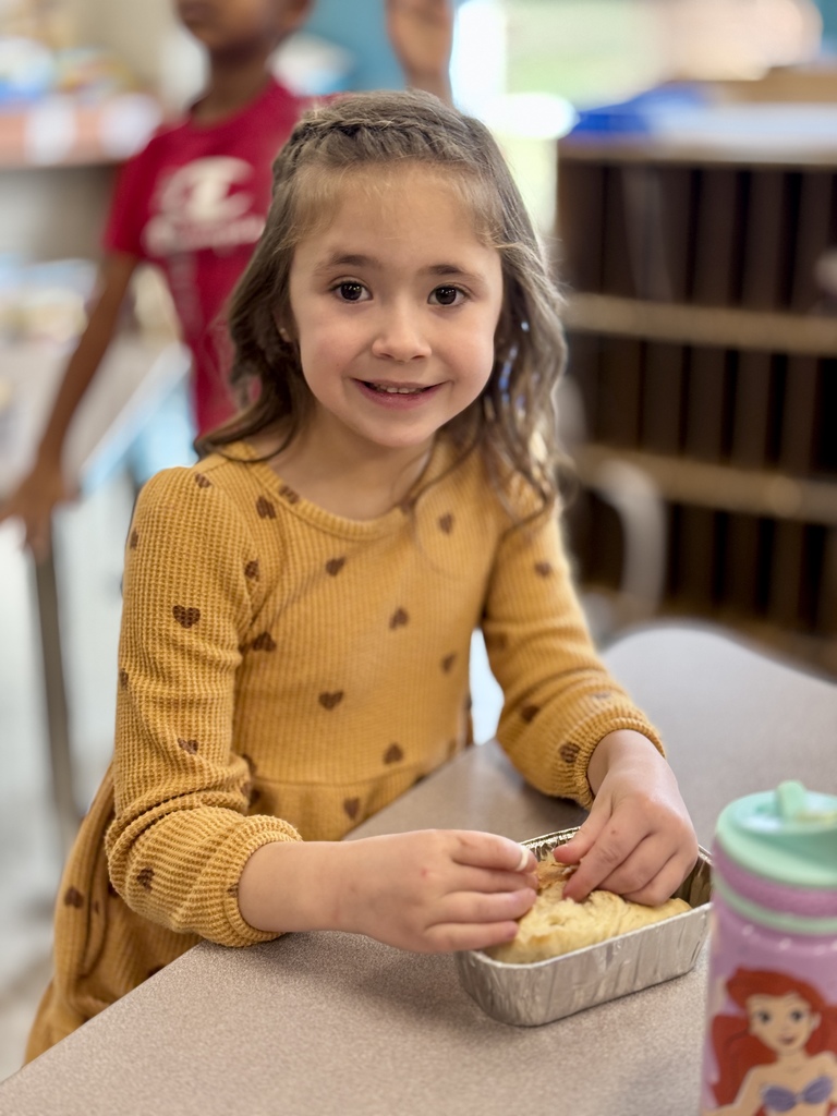 A young student enjoys a bite of homemade bread.