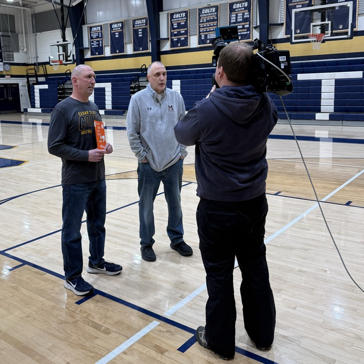 two men in a gym with Dr Seuss book