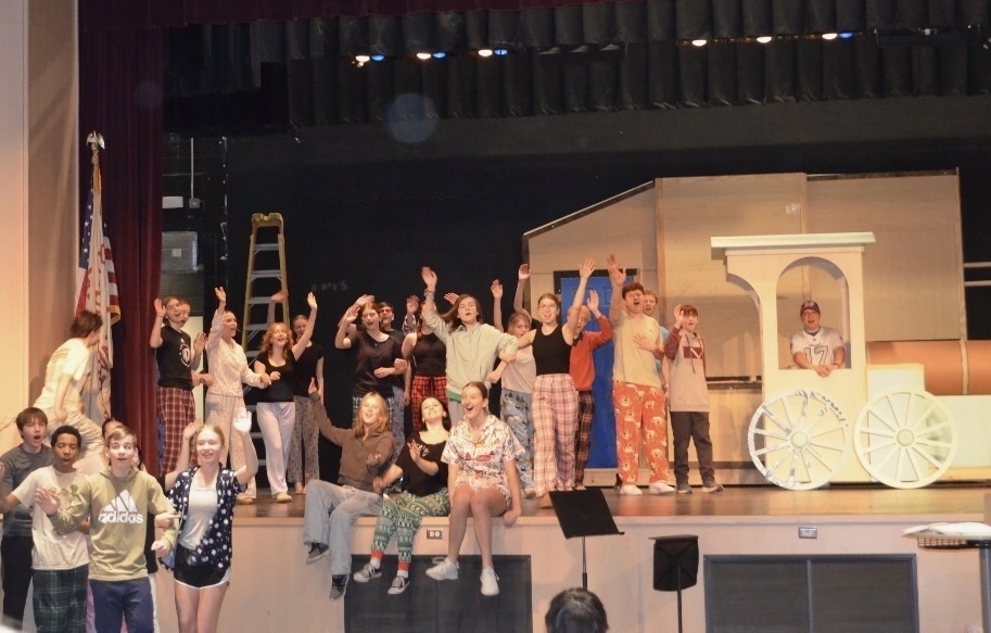 A group of students practicing an on stage musical.