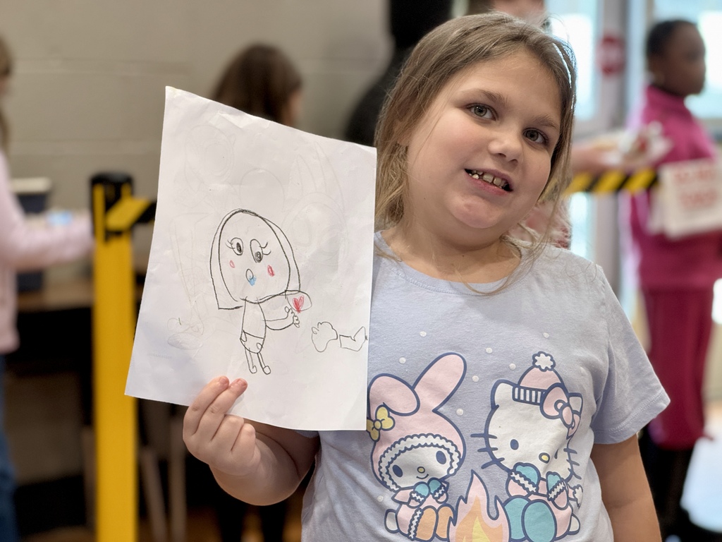 A young students shows off her artwork.