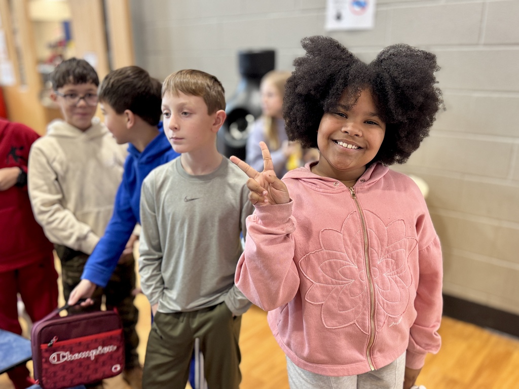 Students smiling in the school cafeteria.