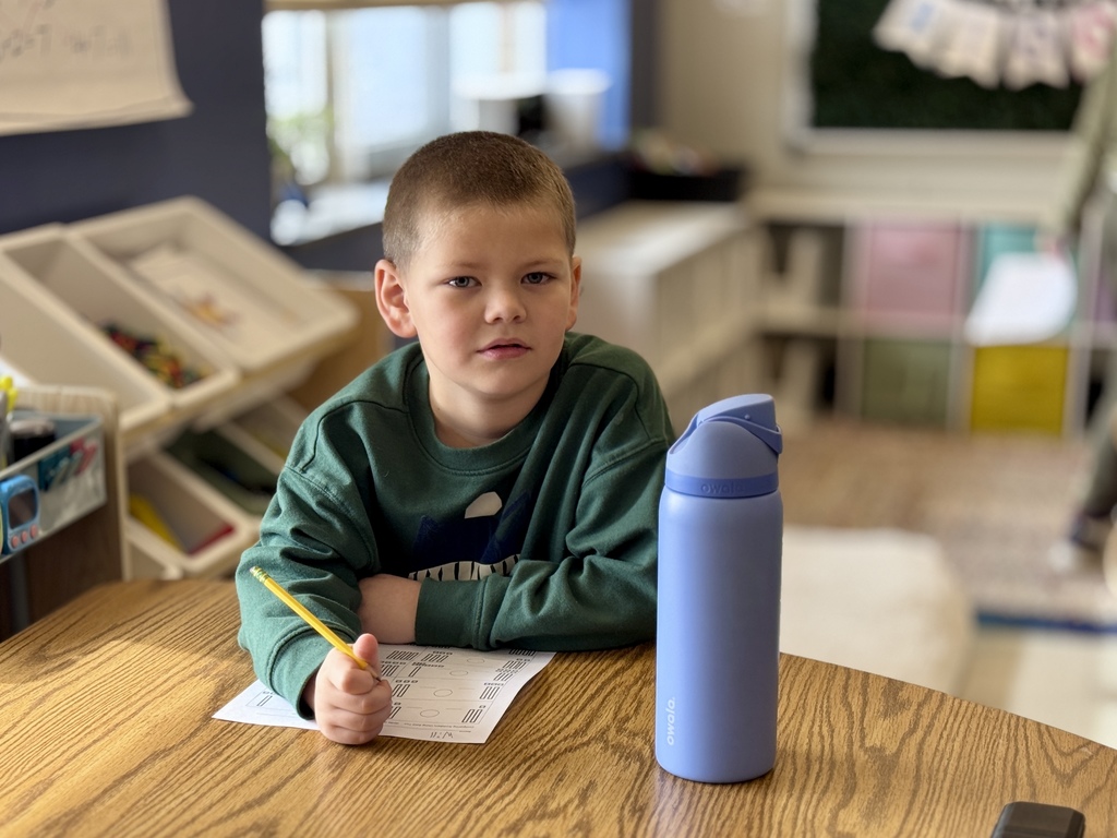 A student working on math at a desk.