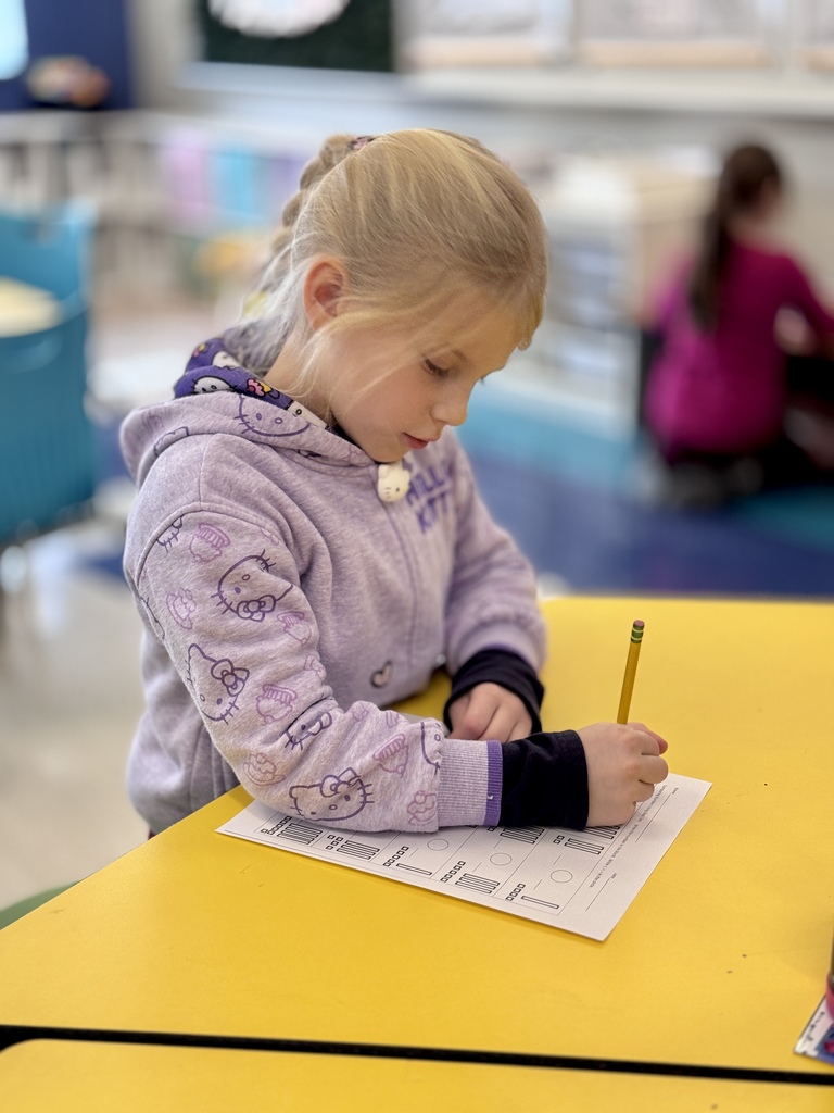 A student working on math at a desk.