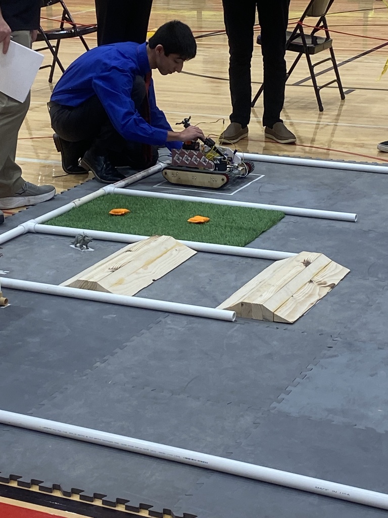 A student setting up a robot that he programmed.
