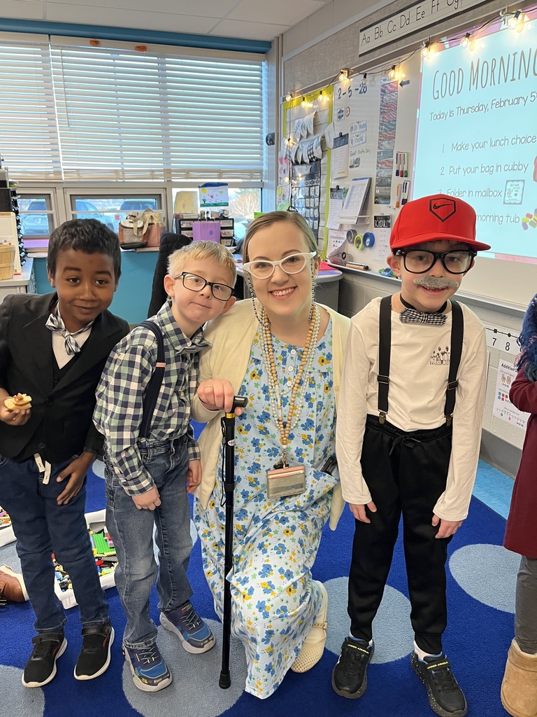 Young students with a teacher and everyone is dressed like they are 100 years old.