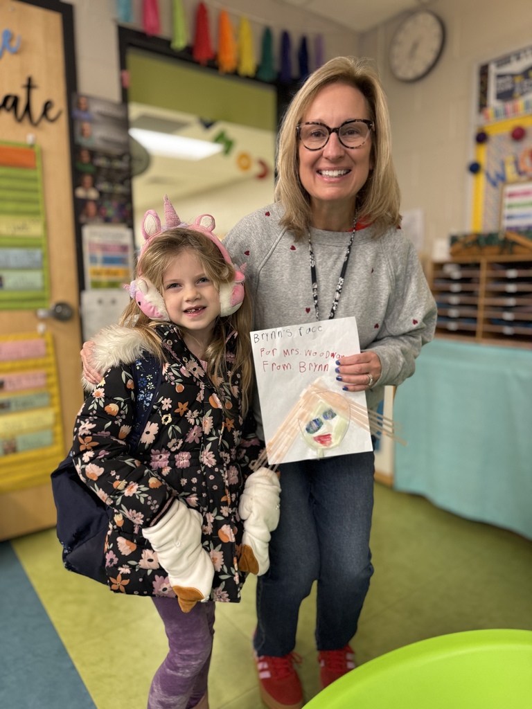 A student gives teacher a drawing she made of the teacher.
