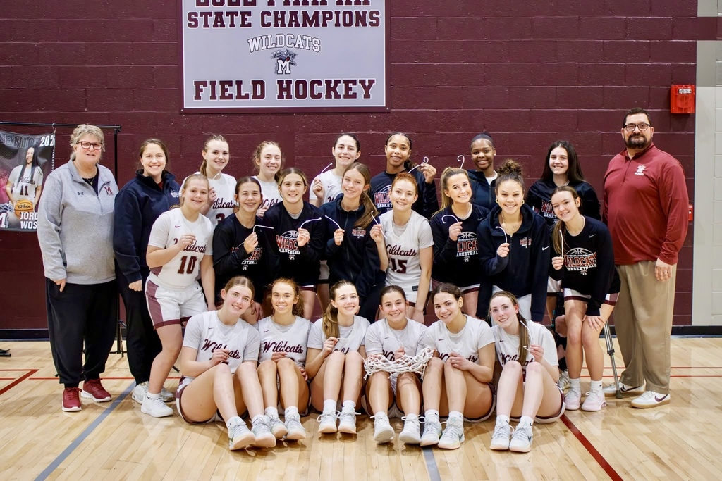 Girls basketball team posing for a win after a championship game.