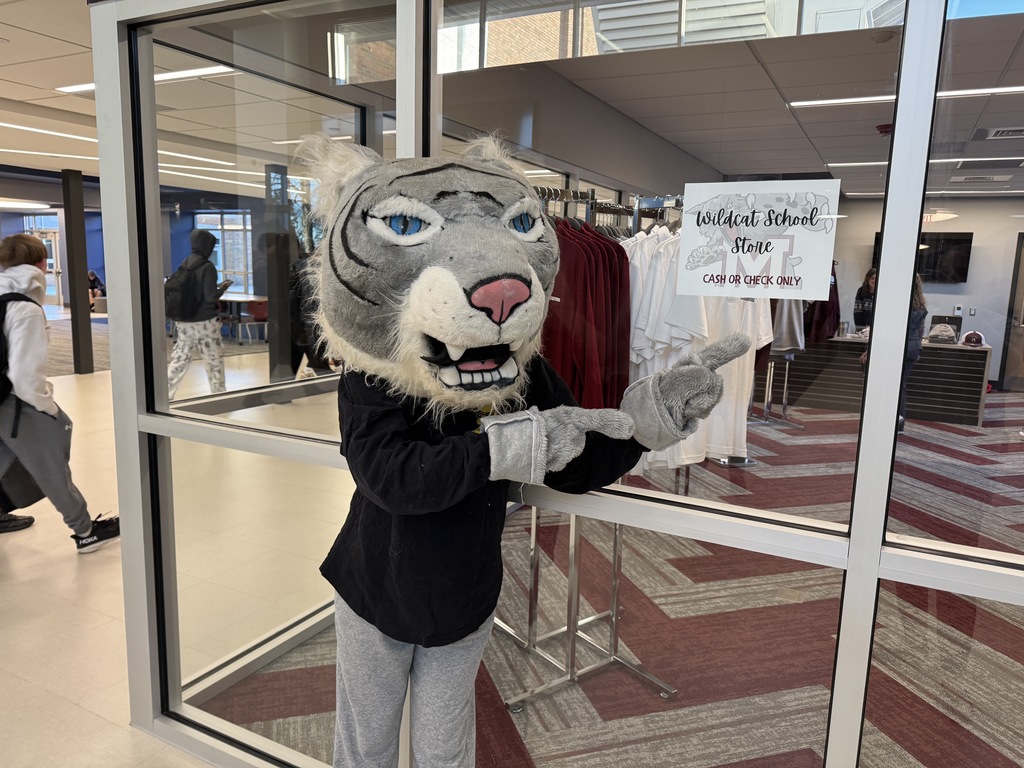 Our wildcat mascot points to a sign announcing our new school store is open for business.