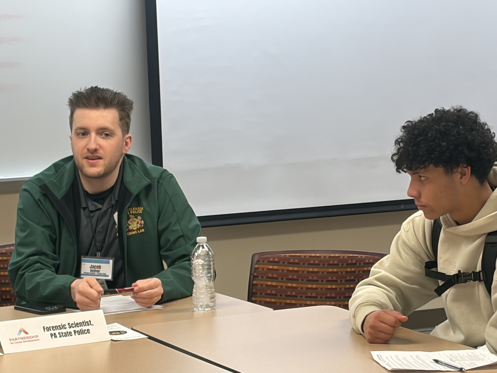 Students gathered around a table and talking with someone in law enforcement.