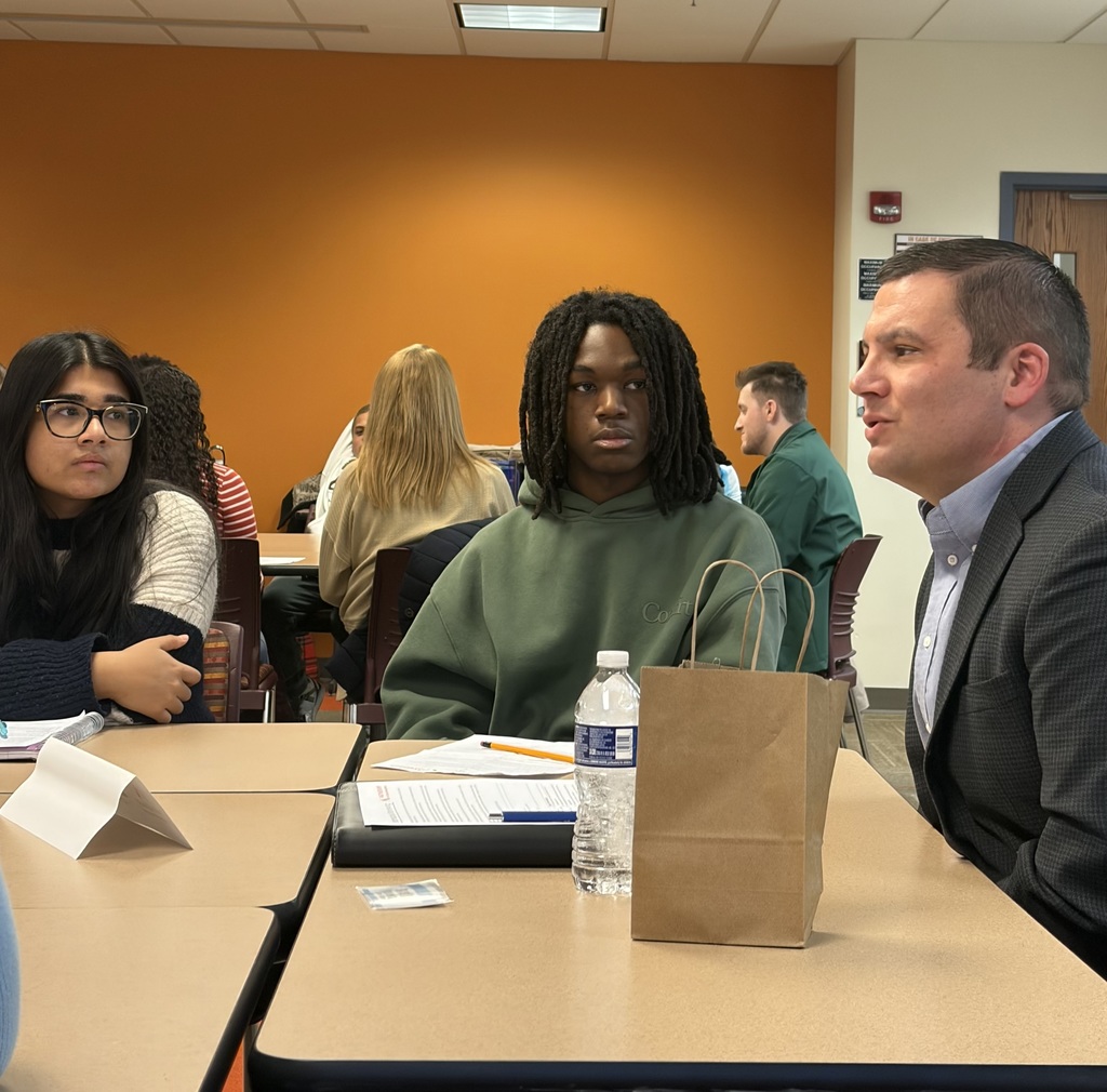 Students gathered around a table and talking with someone in law enforcement.