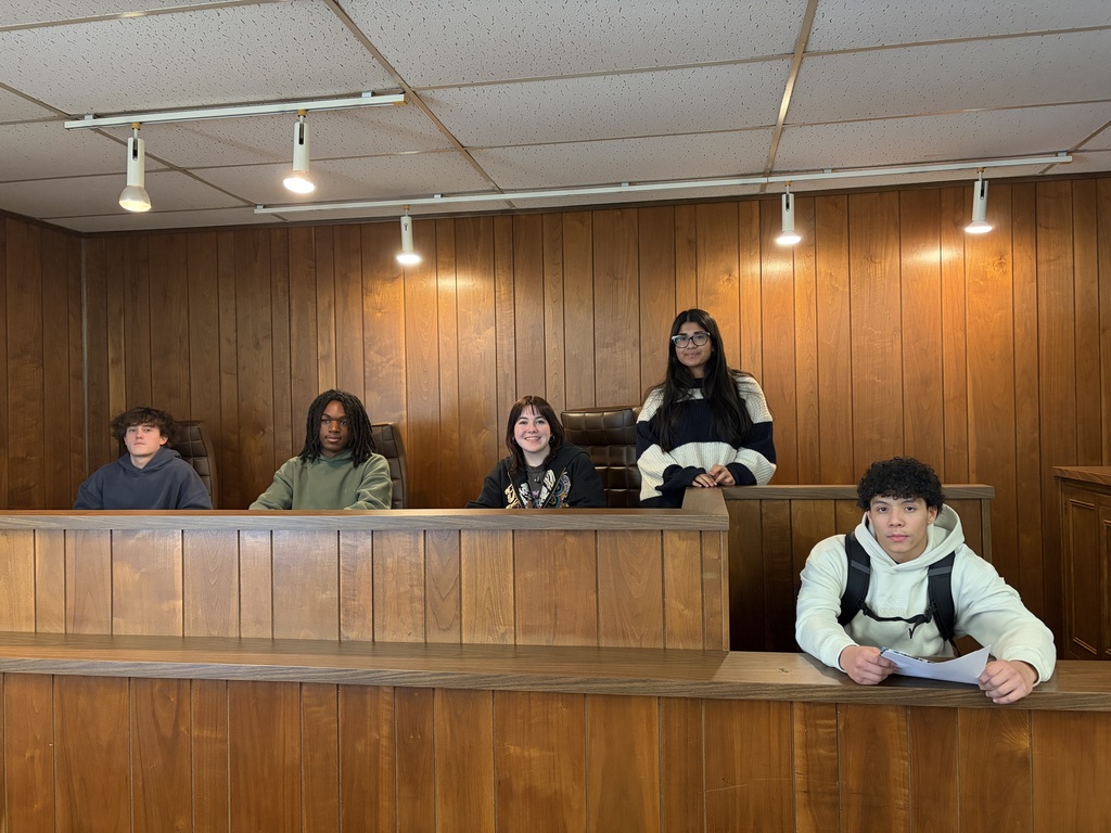 Students sit at the judges table during a career exploration opportunity.