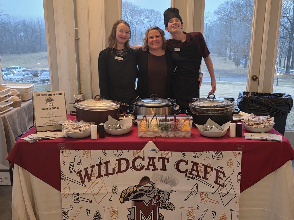 Two students stand alongside their teacher at a special community event.