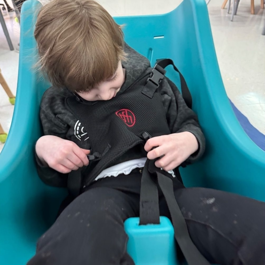 Young student riding an indoor swing.