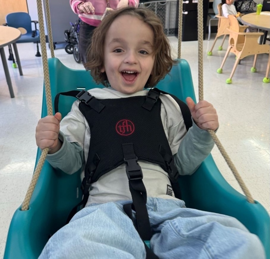Young student riding an indoor swing.