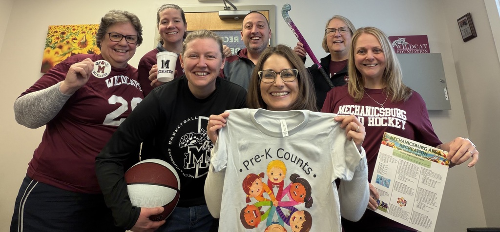 A group of staff wearing maroon Wildcat gear and holding a variety of recreation items.