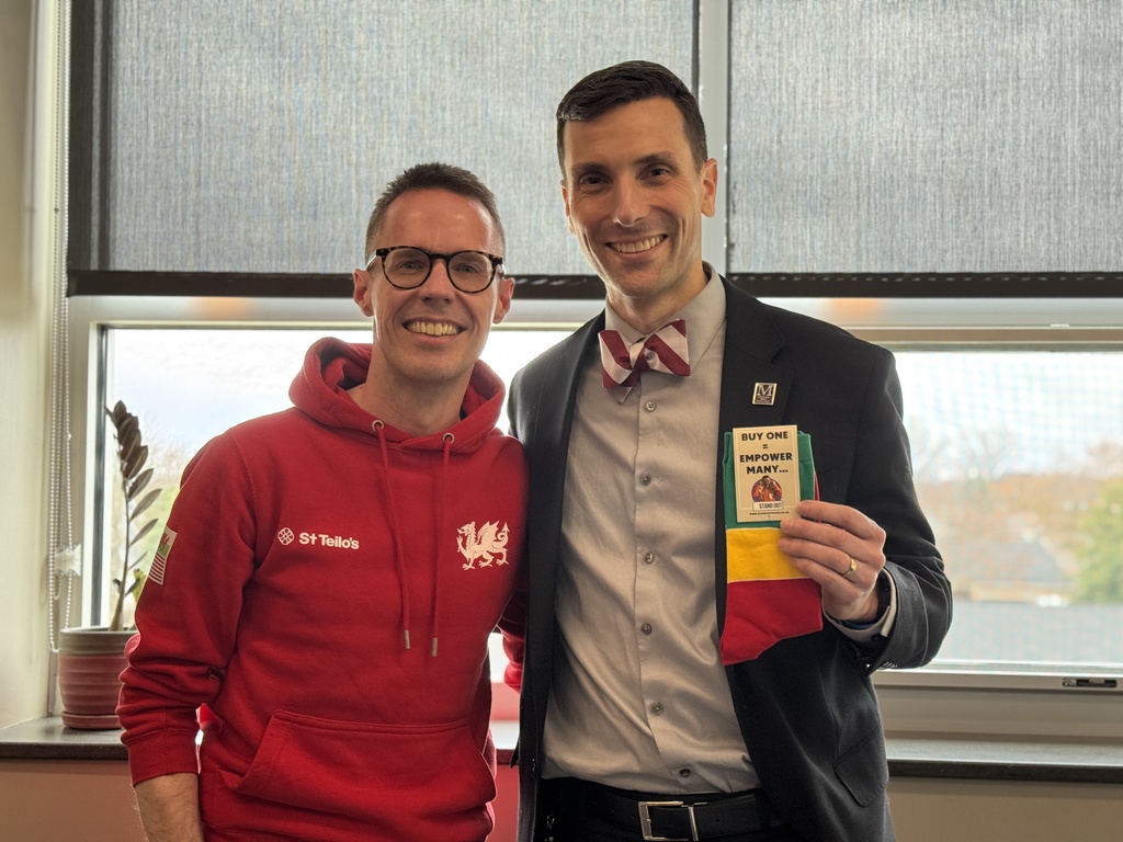 Two men holding a pair of branded socks.