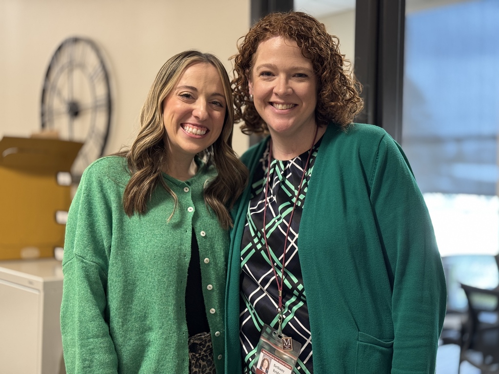 Two adult staff members wearing green for St. Patrick's Day.