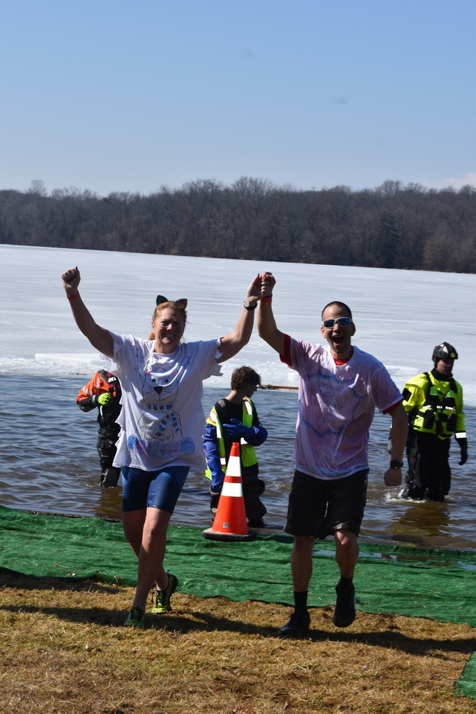 Staff run out of a frozen lake.