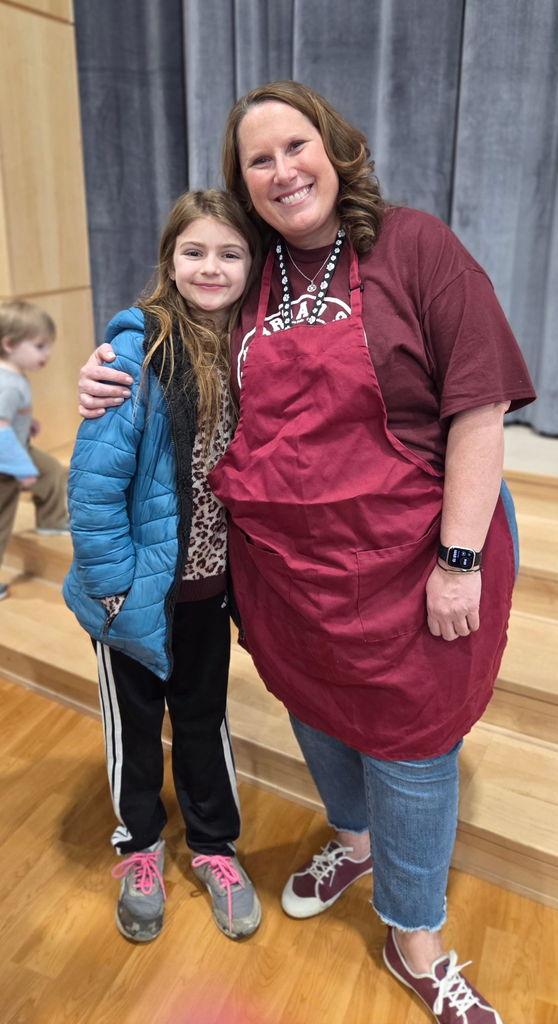 A staff member hugging a young student.
