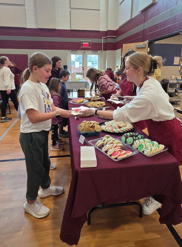 Staff serving dessert to students.