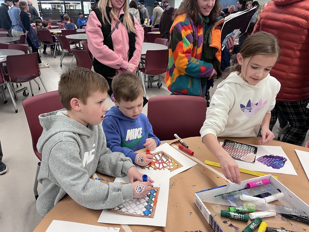 Students at a table creating colorful art.