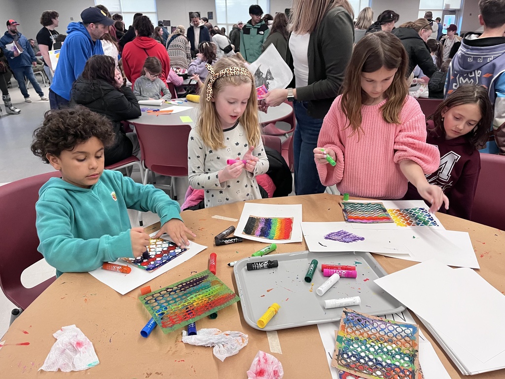 Students at a table creating colorful art.