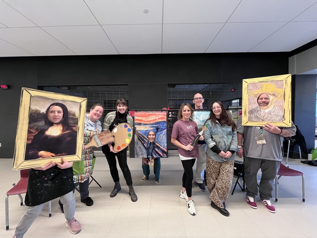 Staff with their faces in cardboard cutouts of famous artists.