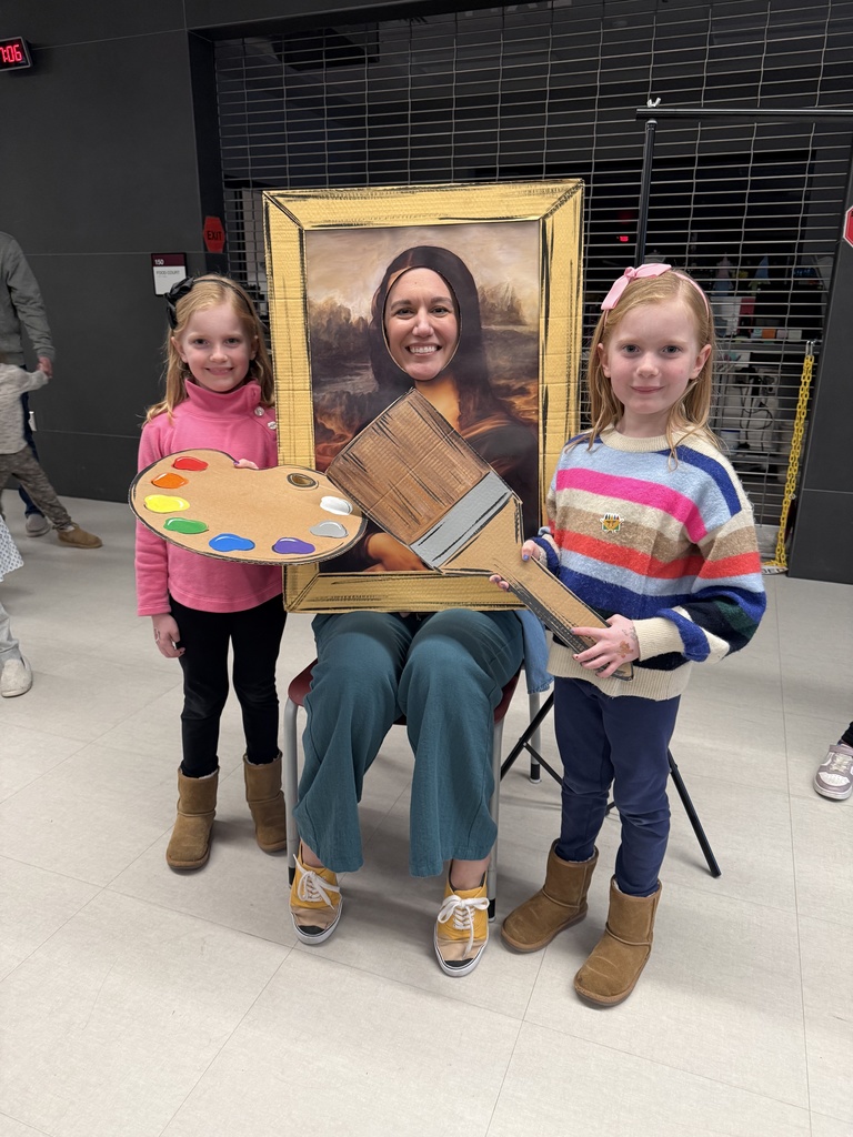 Three people holding cardboard art supplies and their head in a cardboard cutout.