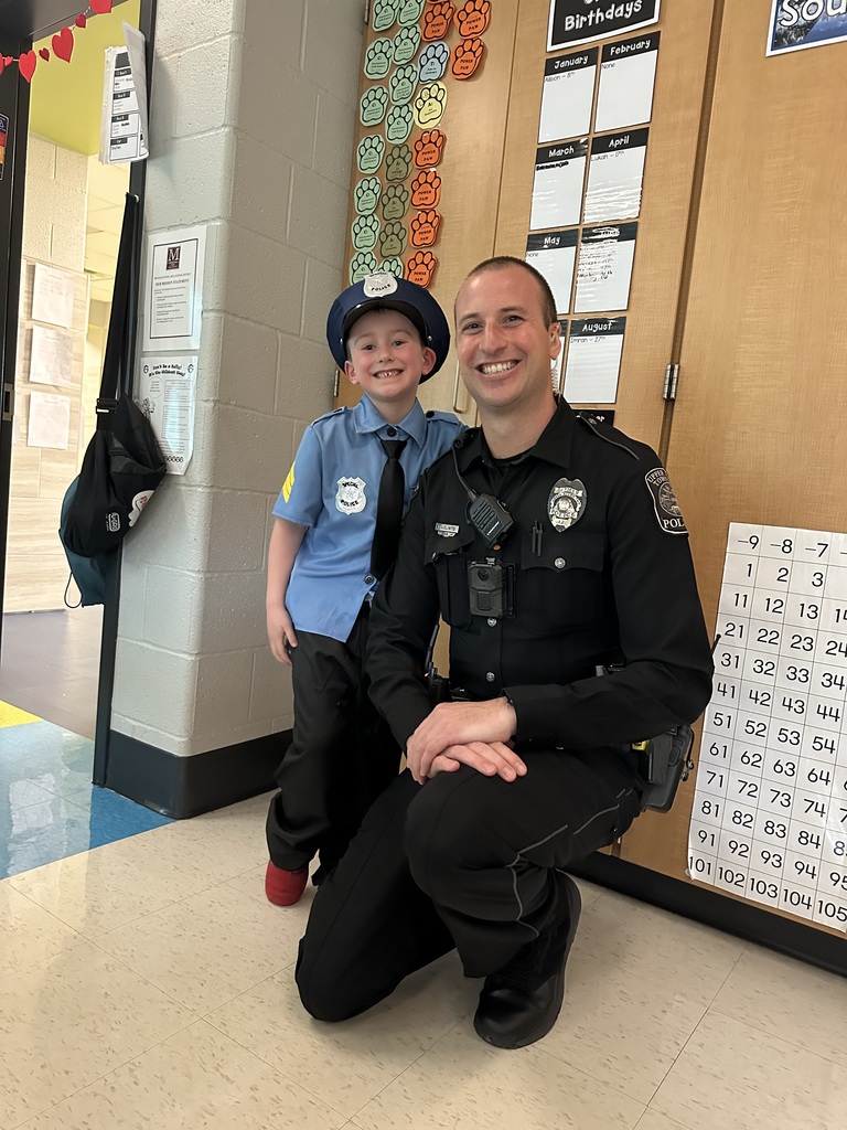 A young boy dressed like a police officer, standing next to a real life police officer.
