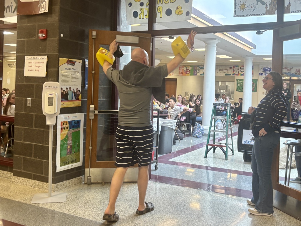 A man walks into a cafeteria with arm floaties on after plunging into a bucket of ice water.