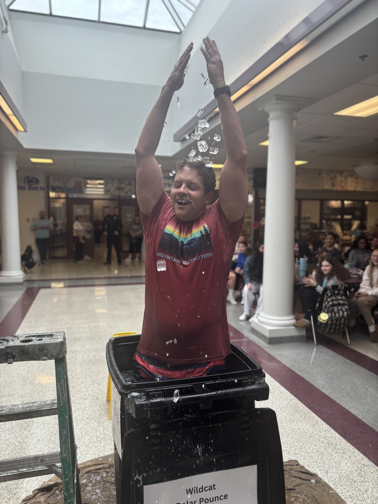 A man dumps ice over his head after plunging into a bucket of ice water.