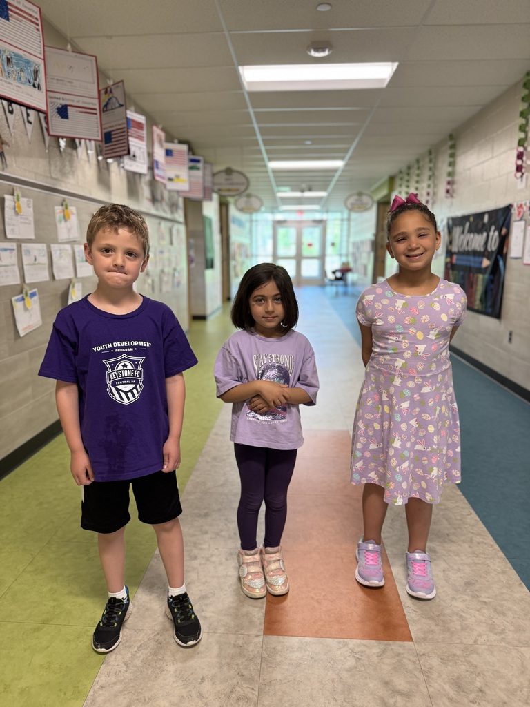 Three young students in purple for Purple Up! day.