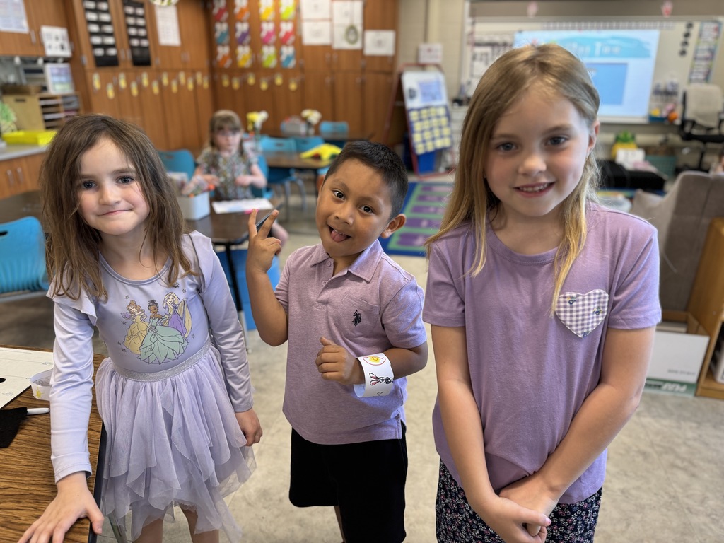 Three young students in purple for Purple Up! day.