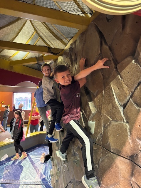 Students climbing up a rock wall.