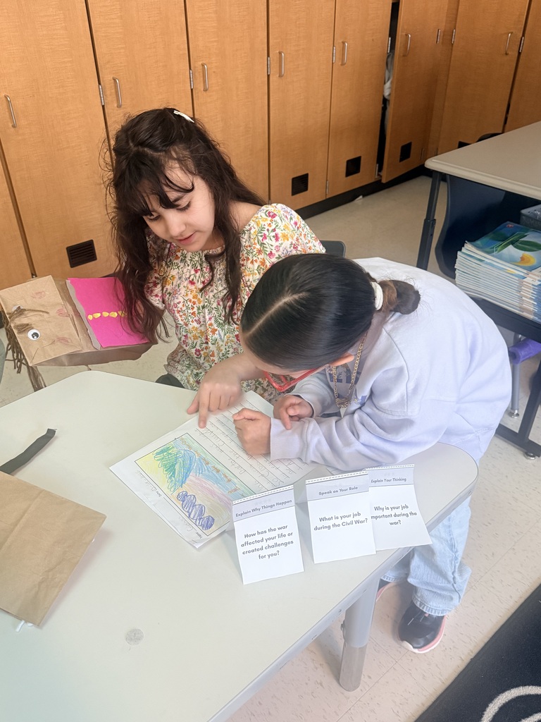 Young students collaborate on history at a table.