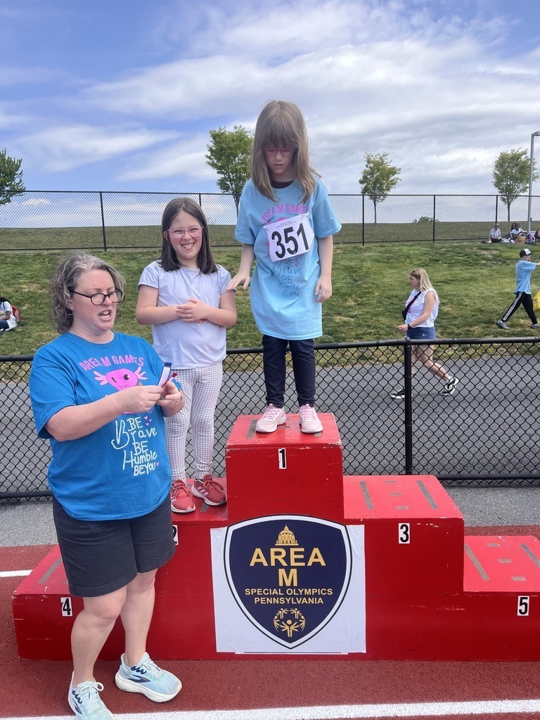A student stands atop the podium at the special olympics.