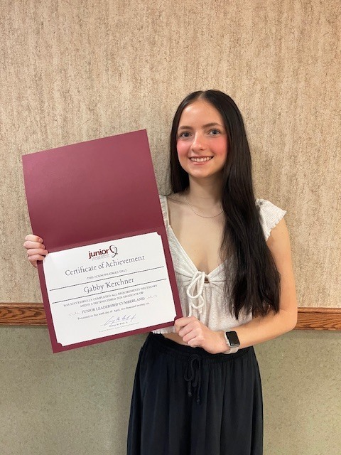 Photo of a female student proudly displaying a Certificate of Achievement.