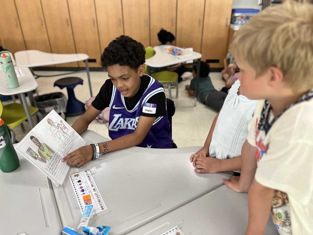 A student reads a self-written biography to young children.