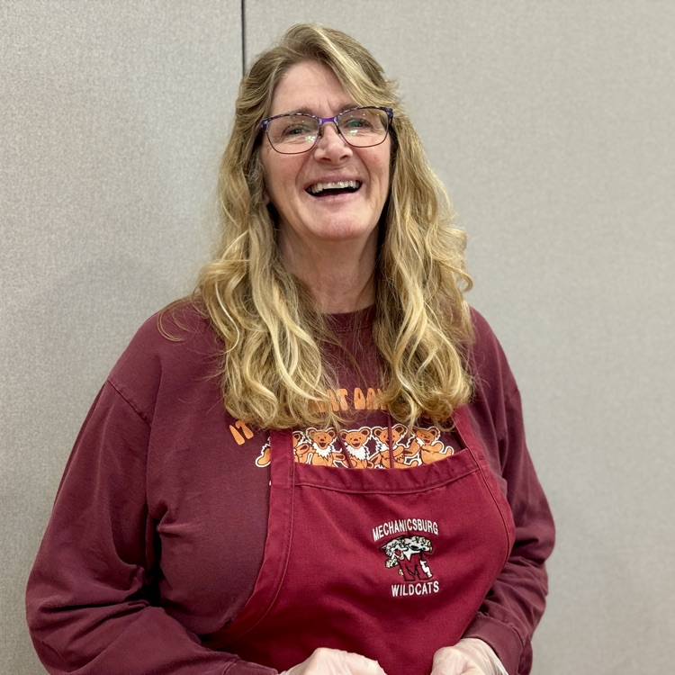 A food service worker smiles