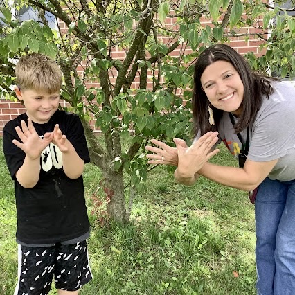 A sign language interpreter teaches a student to sign