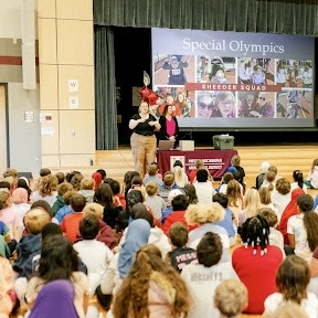 a sign language interpreter signs to a crowd of students