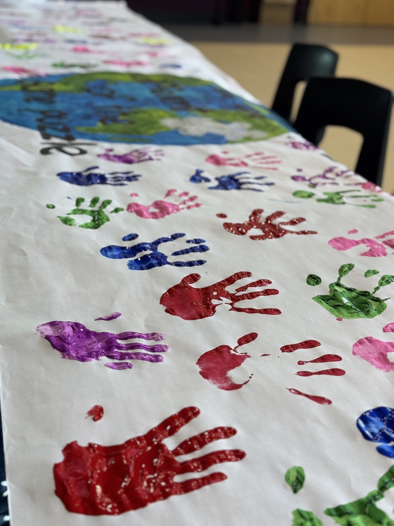 A canvas with a lot of colorful handprints.
